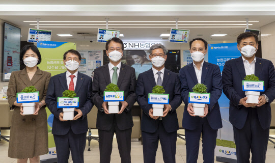 농협금융그룹은 출범 10주년을 맞아 ESG 시리즈 상품을 출시했다고 14일 밝혔다. 서울 중구 소재 농협은행 본점에서 손병환(왼쪽 세번째) NH농협금융지주 회장과 임직원들이 농협금융 출범 10주년 기념 ESG상품 가입행사 후 기념촬영을 하고 있다. 왼쪽부터 이현애 농협은행 개인금융부문장, 박학주 NH-Amundi 자산운용 대표, 손병환 회장, 윤상운 농협카드 사장, 김용기 농협금융지주 사업전략부사장, 황종연 농협금융지주 사업전략부장(NH농협금융 제공).